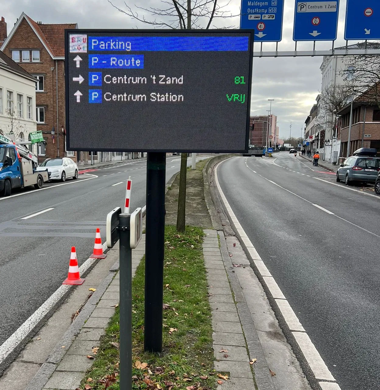 Technicien ajustant le système arrière d'un panneau LED directionnel sur un mât