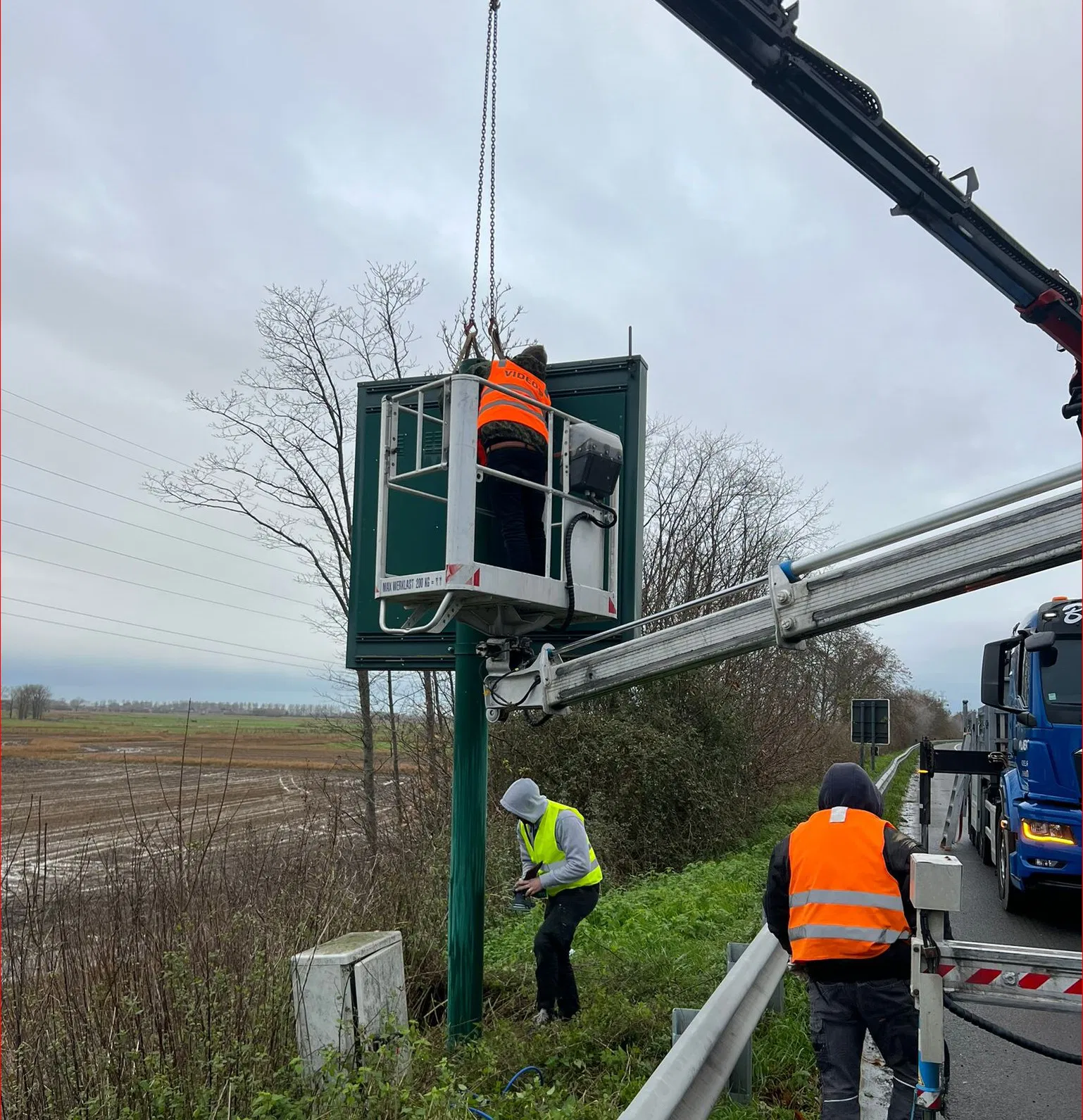 Panneau LED affichant les directions de parking et les distances, avec des voitures circulant sur la route