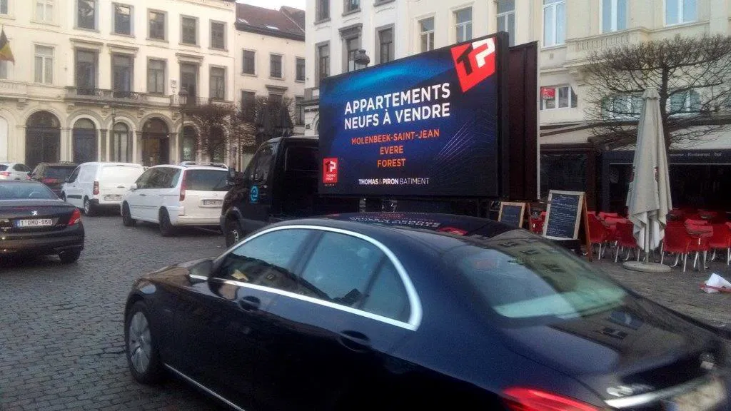 Vue panoramique d'un camion publicitaire mobile avec écran LED grand format en extérieur, idéal pour des campagnes publicitaires modernes et impactantes